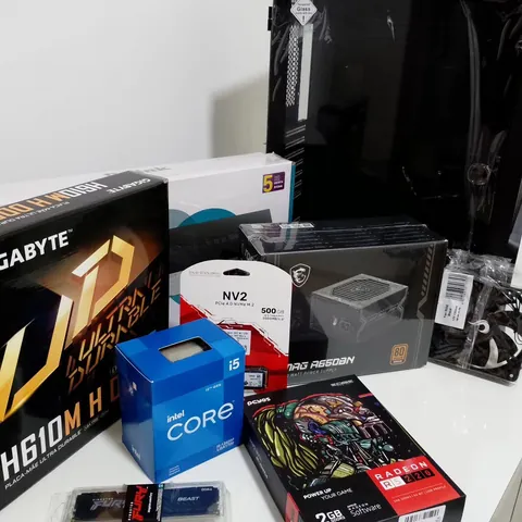 Caixas das peças de um kit antes da montagem: placa-mãe Gigabyte, processador Intel Core i5, SSD NVMe, fonte MSI, memória Kingston Fury e placa de vídeo Radeon